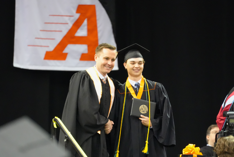 AHS graduate shakes principal Fender's hand after accepting diploma